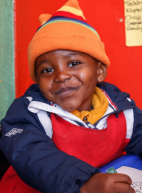 Smiling boy in colorful winter attire.